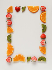 Sliced fruits and berries arranged in a frame. Flat lay with copy space in the middle