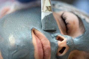 young woman relaxes in a beauty spa after applying a mask on her face