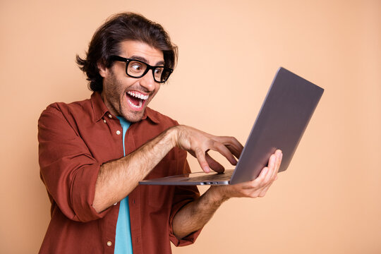 Photo portrait of evil guy laughing typing isolated on pastel beige colored background