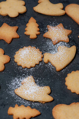 Close-up of delicious homemade Cookies, in preparation for Christmas, displayed on a Slateplate.  Covered with powdered sugar.