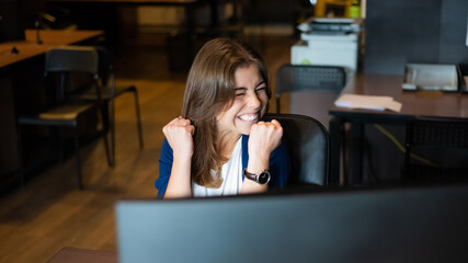 Joyful woman at her desk in the office