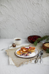 Cheesecakes with cranberries and pine nuts on a gray ceramic plate. Table setting for breakfast.