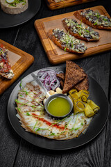 A table set for a group of friends with seafood snacks: bruschetta with salmon and avocado, with herring and tomatoes or cucumbers, forshmak. Festive table with delicious food.