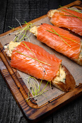 Bruschetta with cheese, avocado and salmon fillet. Delicious nutritious healthy snack. Festive table with delicious food.