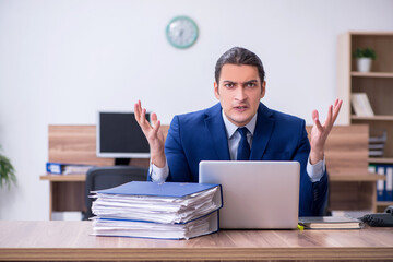 Young male employee unhappy with excessive work