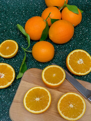View of whole and split oranges on kitchen counter.