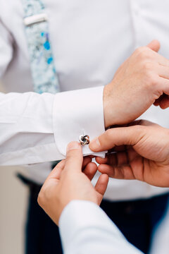 Groom getting ready adjusts a cuffling on his white shirt