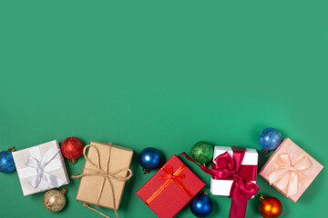 Bright gift boxes and Christmas decorations, on a green background. Top view, holiday and Christmas concept.