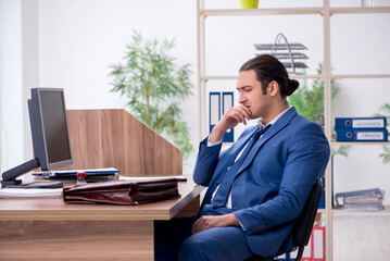 Young male employee businessman at workplace