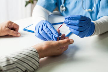 NHS UK doctor taking patient blood sample,serologic finger prick PRP blood antibodies test to...