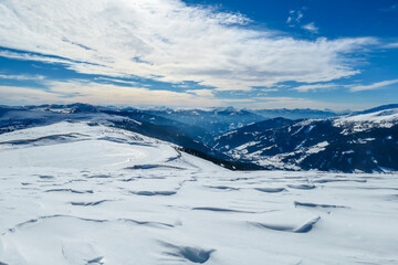 Fototapeta na wymiar A panoramic view on snow capped Alps in Austria, seen from Katschberg Ski Resort in Austria.The slopes are covered with fresh, powder snow. Idyllic winter landscape. Sunny day
