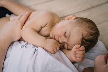 Woman sleeping with her baby in hammock on porch