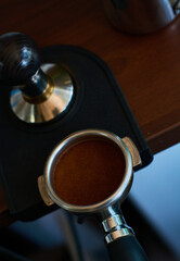 The process of temper coffee in holder, making espresso on coffee machine.