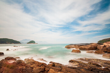 View of the sea with rocks from the natural pools of Trindade, Paraty, RJ. Long exposure shot.
