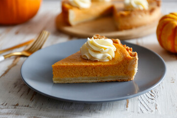 Traditional thanksgiving food on wooden table. Orange delicious homemade pumpkin pie with crust and decorative items. Thanksgiving table setting concept.Top view, close up, copy space, background.