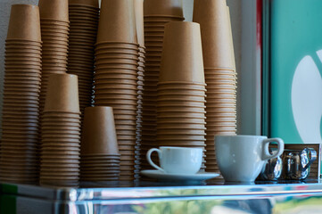 Professional coffee machine in coffee shop with empty craft disposable cups.