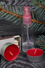 Branches of blue spruce on pine boards. Nearby are red candles, a box of matches and an antiseptic. Close-up shot.