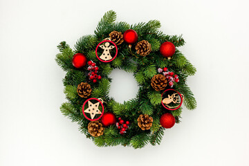 top view of decorative festive wreath with red a christmas toys on white