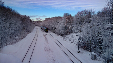 Obraz premium Green train in snow with Tyseley incinerator