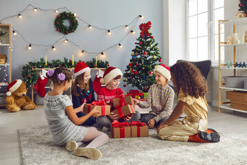 Group of happy mixed race children having home Christmas party and giving presents