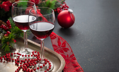 Christmas red wine glasses and xmas decoration on the table, closeup view