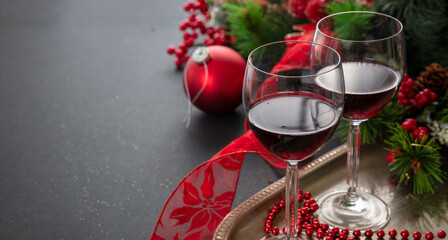 Christmas red wine glasses and xmas decoration on the table, closeup view