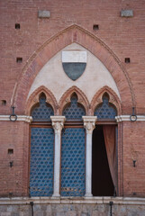 
historic arched window with stone columns on the facade of a red brick building