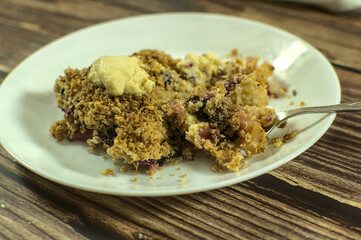 Piece of Apple and blueberry crumble with English cream