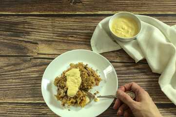 Piece of Apple and blueberry crumble with English cream