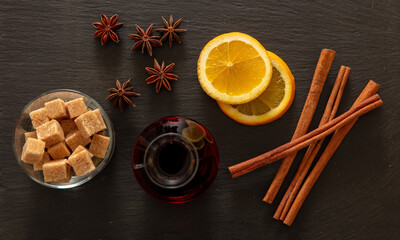Mulled wine recipe ingredients, Christmas hot drink. Orange, cinnamon, star anise and sugar on black stone