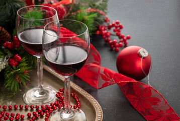 Christmas red wine glasses and xmas decoration on the table, closeup view
