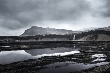Landscape around Seljalandsfoss waterfall on a dark and moody Nordic spring day in southern Iceland

