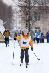 Young Caucasian girl running cross-country ski at competition, winter activities
