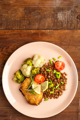 Baked rya with broccoli and lentils in a beige plate. Copy space.
