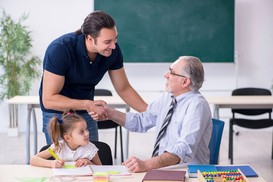 Young Parent, Old Male Teacher And Little Girl In The Classroom