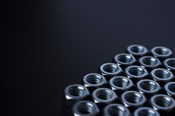 screw-nuts on a dark surface