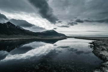 Iceland reflection of mountain and dramatic storm clouds at sunset
