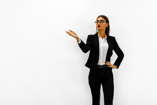 Attractive young business woman making a presentation to her colleagues and pointing to a white background in a conference room at the office. Strategy