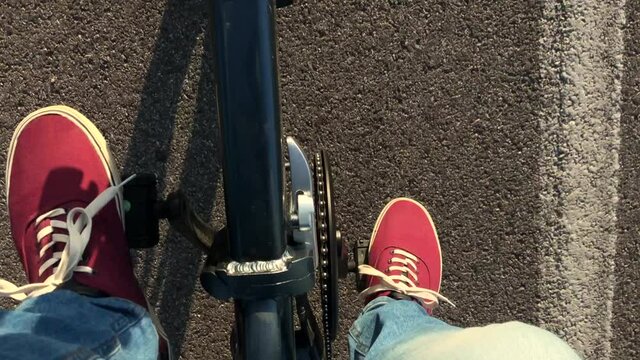 Slow motion: woman or man rides his e bicycle at sunset. Point of view from top. Freedom concept
