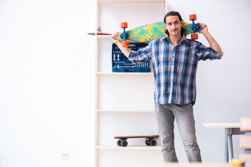Young man repairing skateboard at workshop