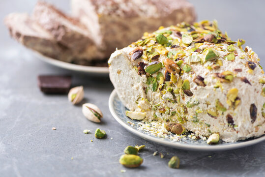 Sesame chocolate halva and halva with pistachios on grey background. Top view. Copy space. Traditional middle eastern sweets. Jewish, turkish, arabic national dessert. Turkish delight