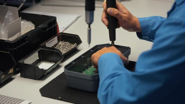 Worker in electronics manufacturing soldering a component