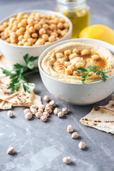 Hummus, chickpea dip, olive oil, raw beans, smoked paprika, pita on grey authentic background. Middle eastern, jewish cuisine or arabic dishes. Macro view. Copy space. Vegan, vegetarian food concept