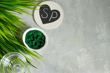 Spirulina powder on a light background. Healthy nutritional supplement for vegan, vegetarian, or plant-based diets. Contains multivitamins