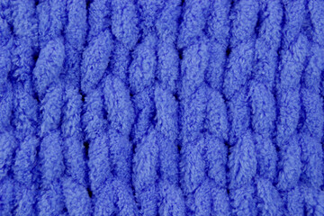 Close-up seamless knitted fabric of blue color, cozy winter knitted background. Unusual abstract texture background. Winter mood and cozy time at home