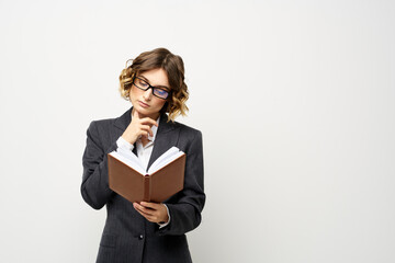 Business woman with notepad and glasses work light background cropped view of suit model.