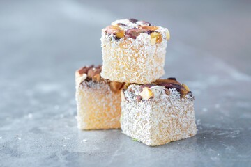 Turkish delight - lokum or rahat lokum with pistachios on grey background. Traditional eastern cuisine. Traditional middle eastern sweets. Jewish, turkish, arabic national dessert. Turkish delight