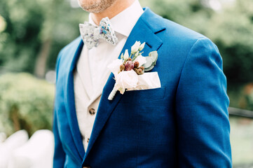 The groom in a navy blue suit with a buttonhole