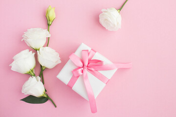 Top view of  gift box, white and pink flowers on the pink  background