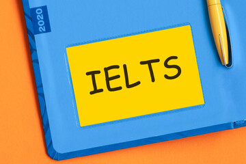 ielts the word is written in black letters on the yellow paper for notes